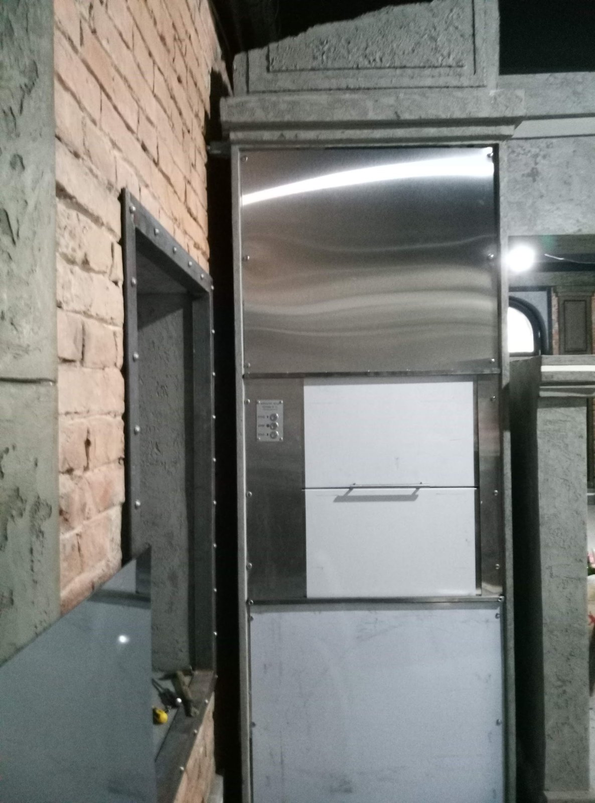 Maloteretni lift ugrađen u prostoru sa dekorativnom ciglom