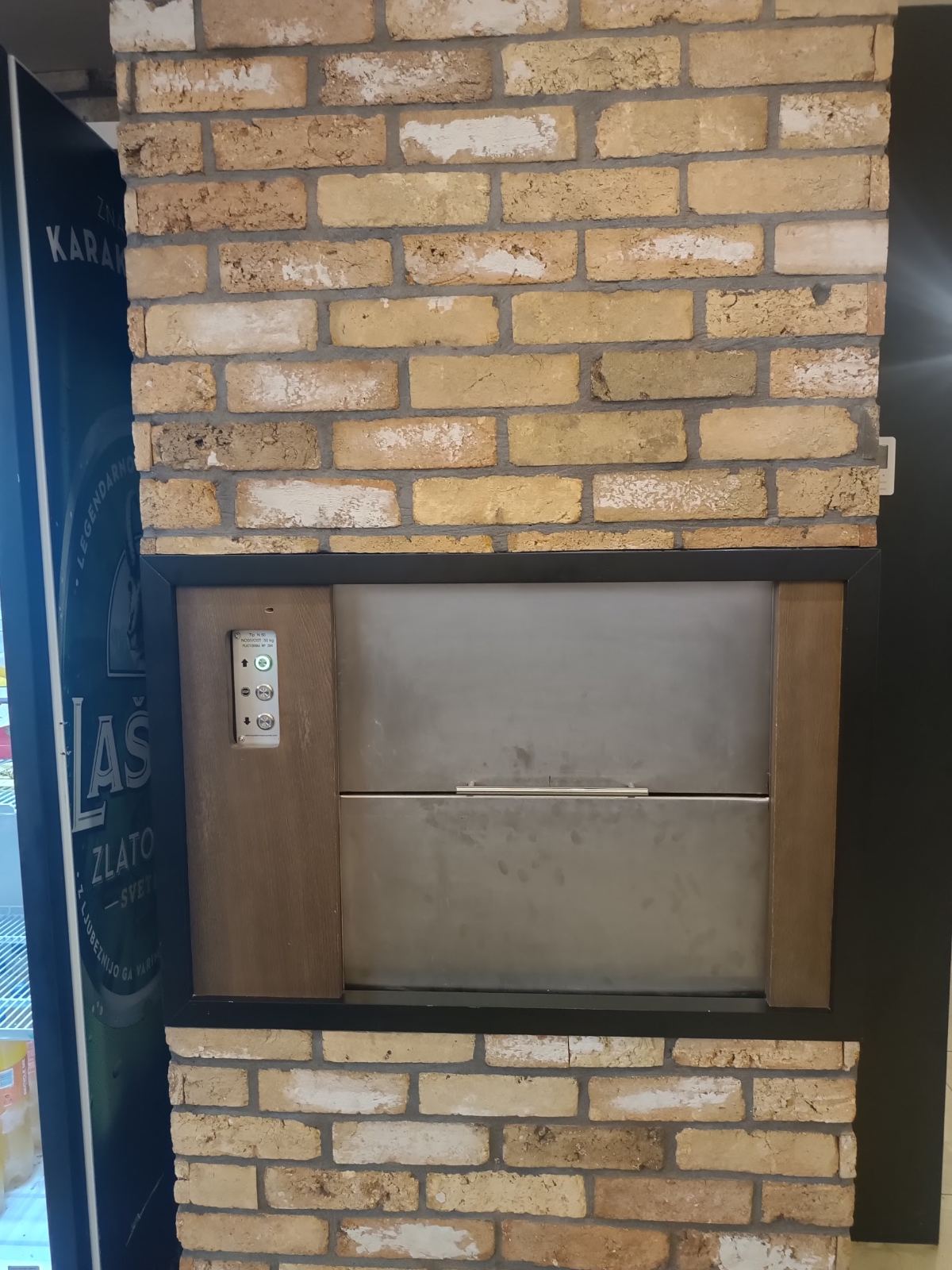 Maloteretni lift uklopljen u enterijer sa zidom od cigle